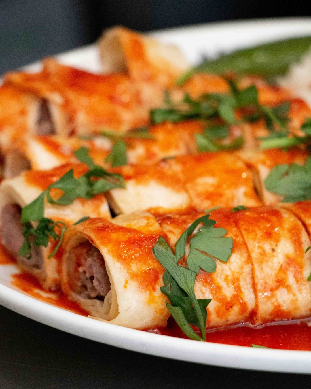 A plate of rolled tortillas filled with meat and topped with a red sauce at Lale, a halal restaurant in Schaerbeek, Belgium.
