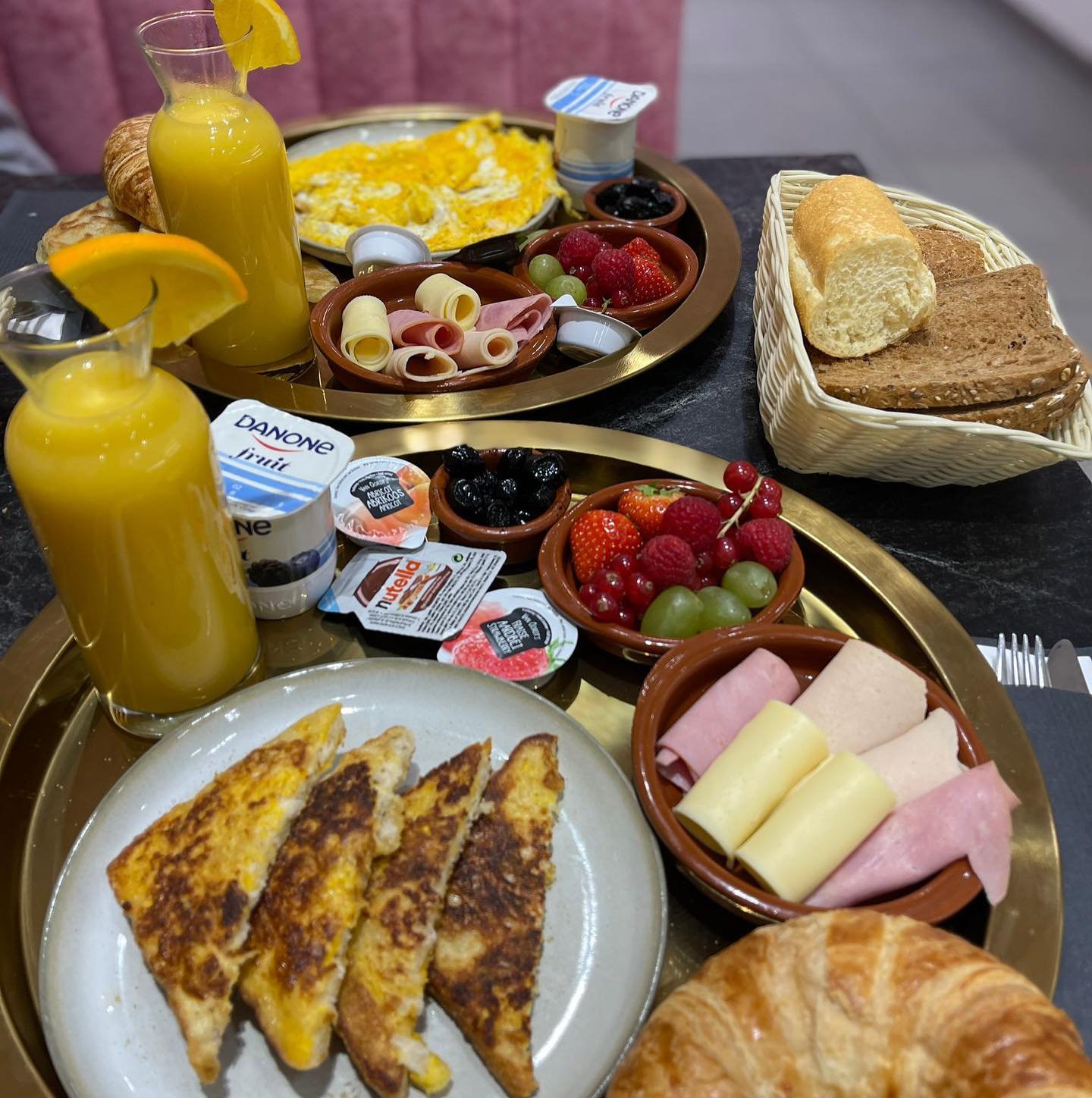 A breakfast platter featuring omelette, toast, cold cuts, cheese, fruits, yogurt, and orange juice at La Delicé Café, a halal restaurant in Mechelen, Belgium.