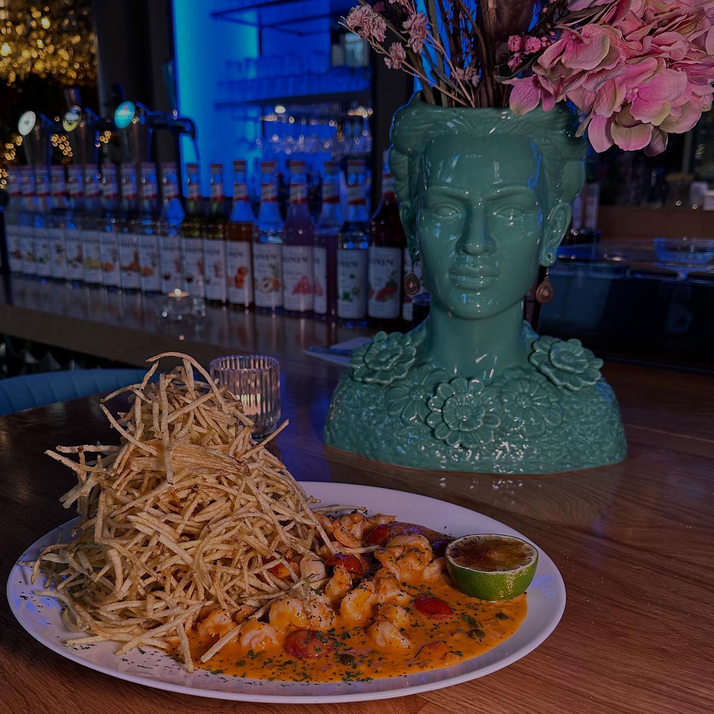 A plate of shrimp in a creamy sauce with a pile of crispy fries at GIA Restaurant, a halal restaurant in Amsterdam, Netherlands.