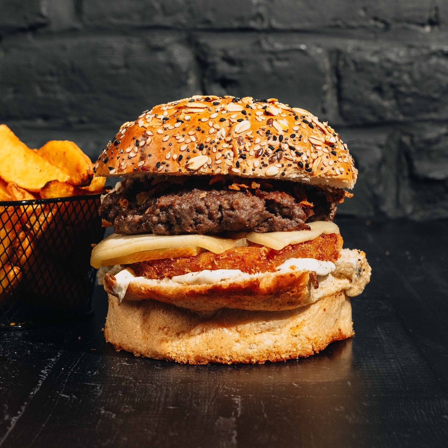 A sesame seed burger with a beef patty, cheese, and crispy onion at Le Passage, a halal restaurant in Molenbeek-Saint-Jean, Belgium.