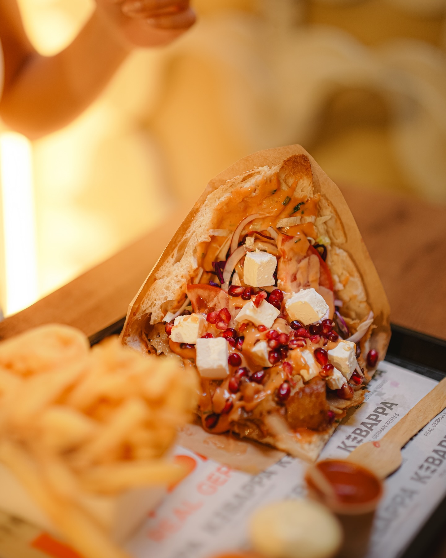 A kebab dish topped with sauce, pomegranate seeds, and feta cheese at Kebappa, a halal restaurant in Schaerbeek, Belgium.