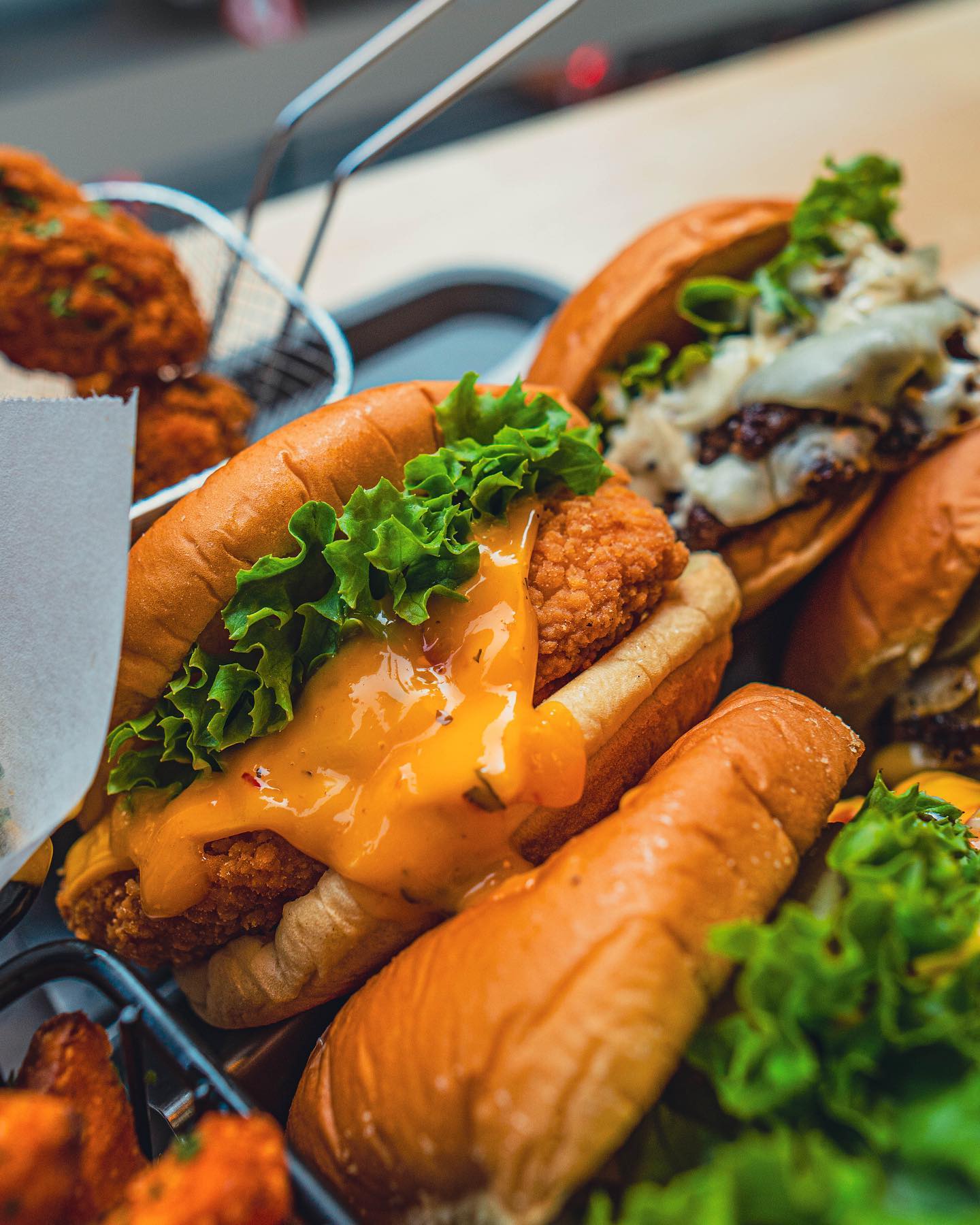 A close-up of a chicken sandwich with lettuce and cheese sauce at Nub Smashburger, a halal restaurant in Gent, Belgium.