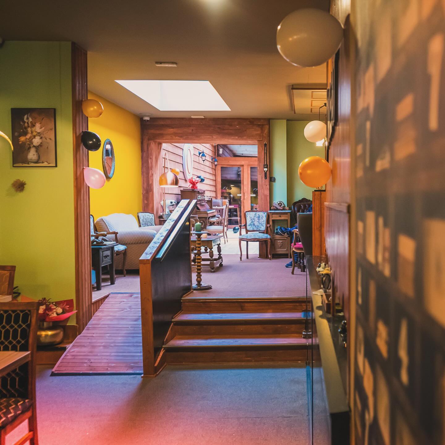 The interior of halal restaurant O'Tweat in Jette, Belgium, showing a cozy seating area with colorful walls, decorative balloons, and wooden accents.