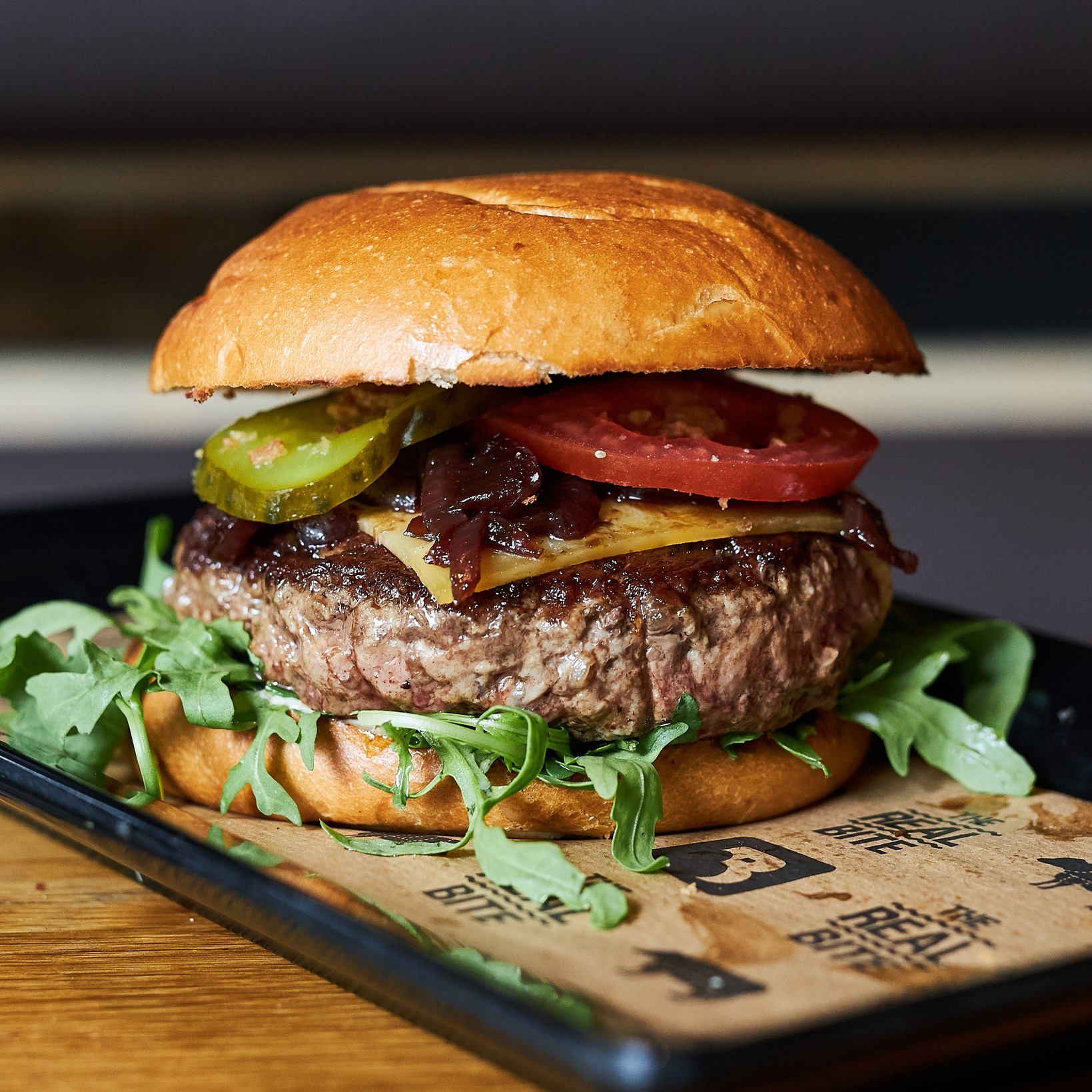 A beef burger with cheese, pickles, tomatoes, and arugula at Burger Bar, a halal restaurant in Amsterdam, Netherlands.