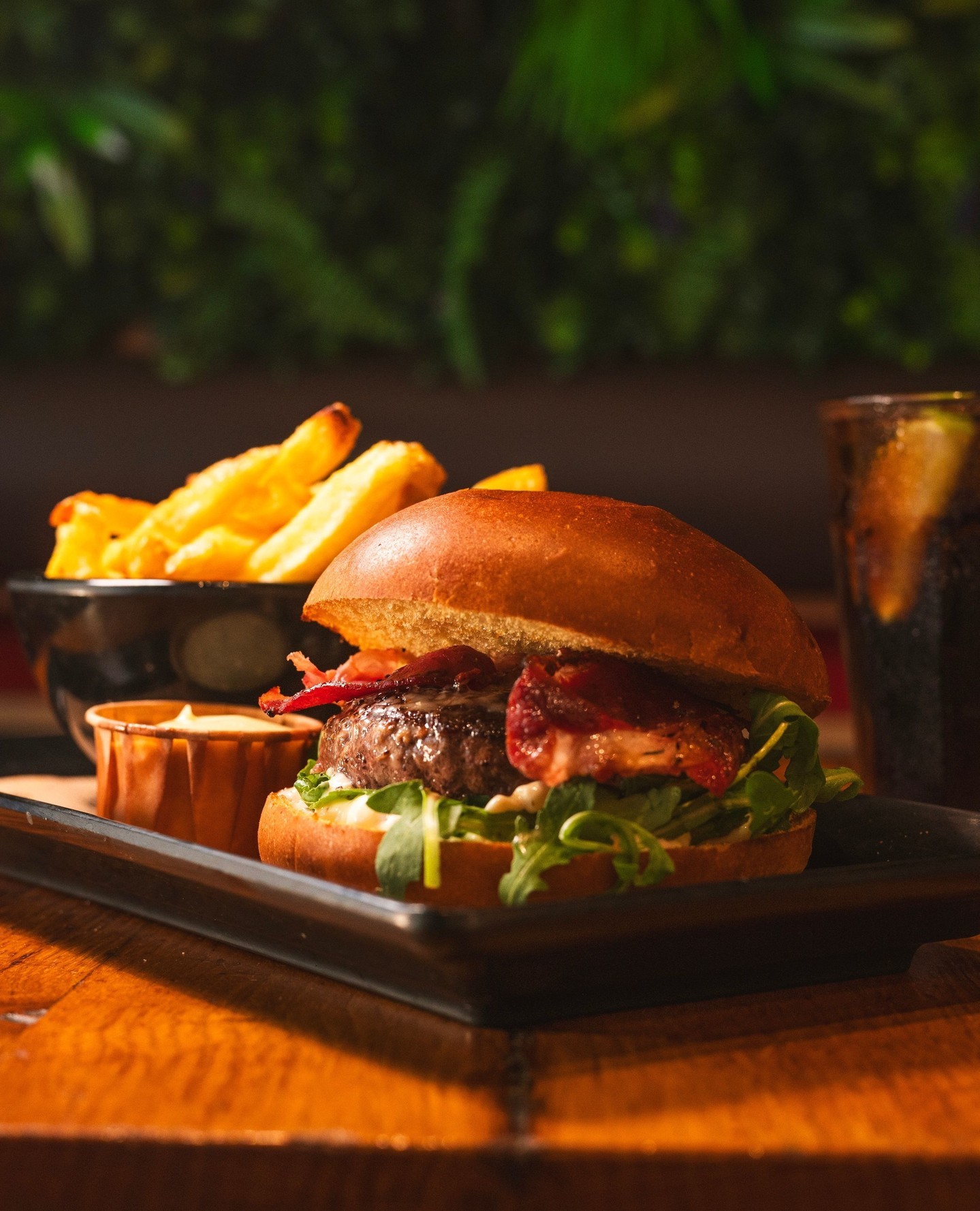 A burger with bacon, lettuce, and sauce, served with fries at Burger Bar, a halal restaurant in Amsterdam, Netherlands.