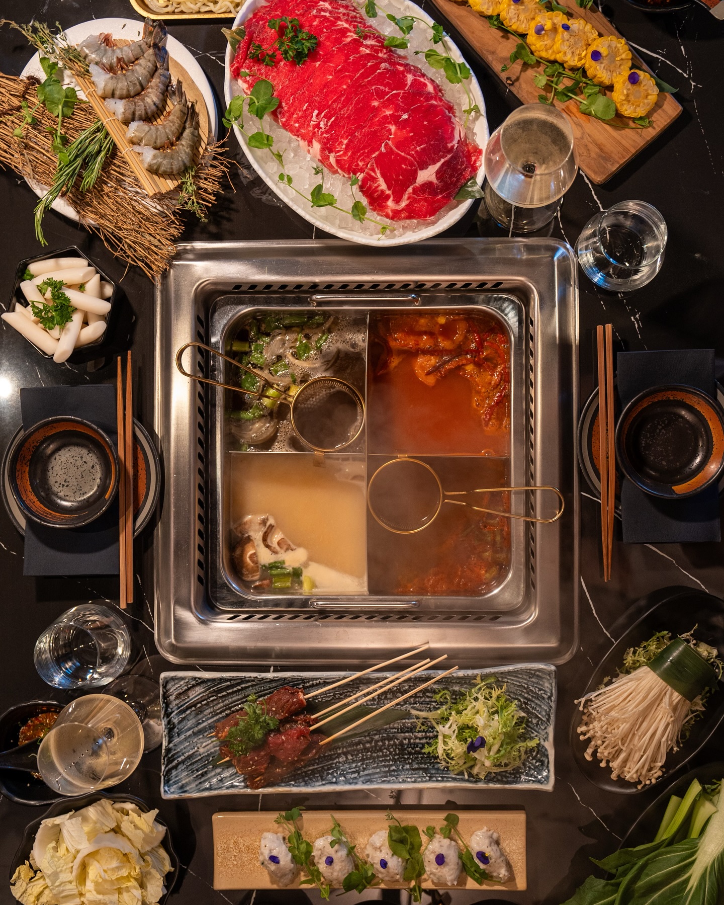 A hot pot dish featuring various ingredients such as shrimp, beef, and vegetables at Sorae, a halal restaurant in Eindhoven, Netherlands.