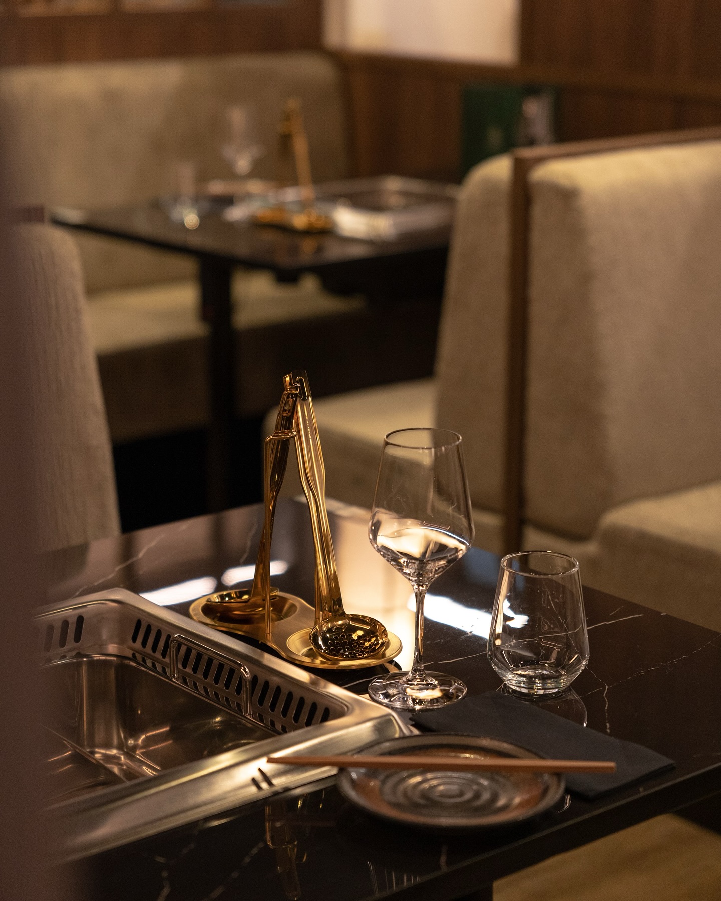The interior of halal restaurant Sorae in Eindhoven, Netherlands, showing elegant seating, a dark marble table, and glassware arranged for dining.