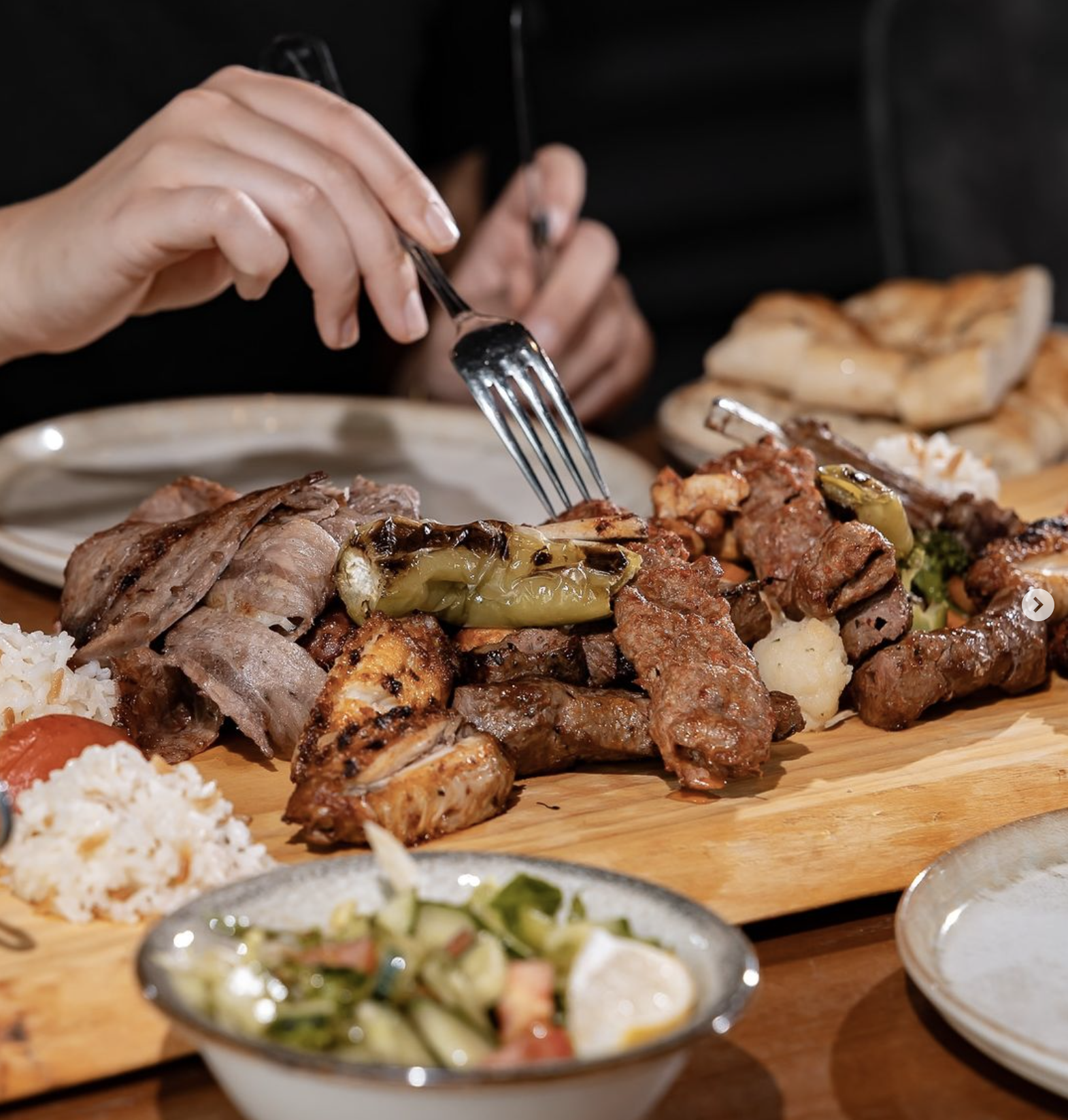 A platter of grilled meats, including chicken and beef, served with rice and vegetables at Mansion, a halal restaurant in Rotterdam, Netherlands.