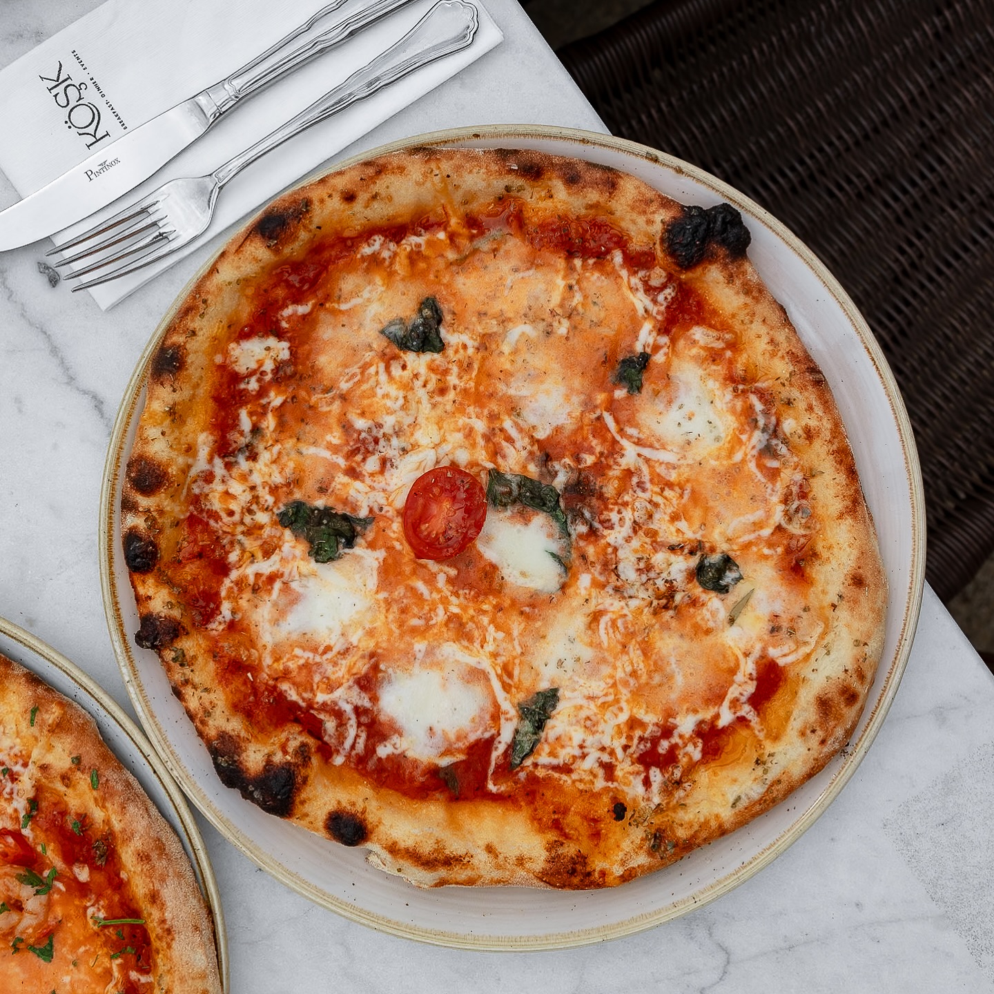 A pizza with tomato sauce, mozzarella cheese, and basil at Mansion, a halal restaurant in Rotterdam, Netherlands.