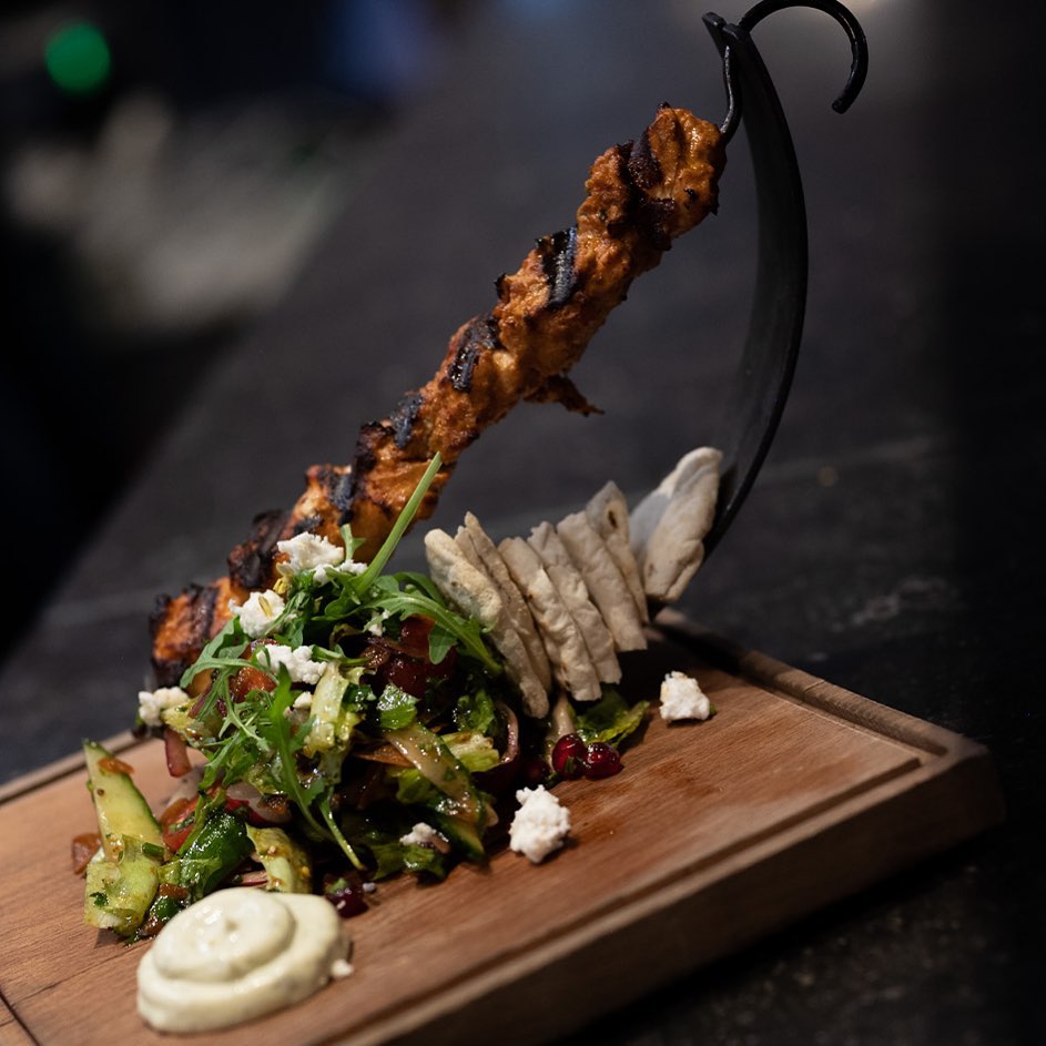A grilled chicken skewer served with a fresh salad and pita bread at Felfel, a halal restaurant in Antwerpen, Belgium.