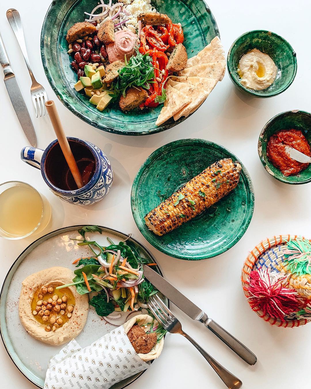 A colorful bowl of falafel, beans, avocado, and vegetables, served with pita bread and hummus at Felfel, a halal restaurant in Antwerpen, Belgium.