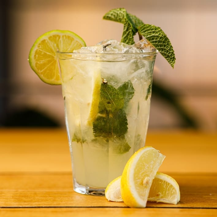 A refreshing glass of lemonade with mint and lemon slices, perfect for a hot day. This drink is a popular choice at Ganii Kebap, a halal restaurant in Rotterdam, Netherlands.