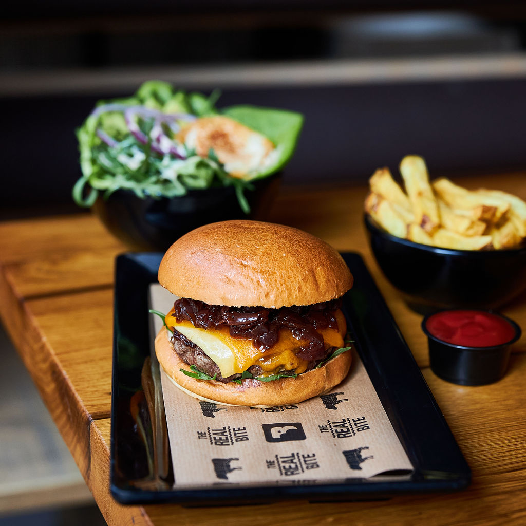 A cheeseburger with caramelized onions and lettuce, served with fries and a side salad at Burger Bar, a halal restaurant in Amsterdam, Netherlands.
