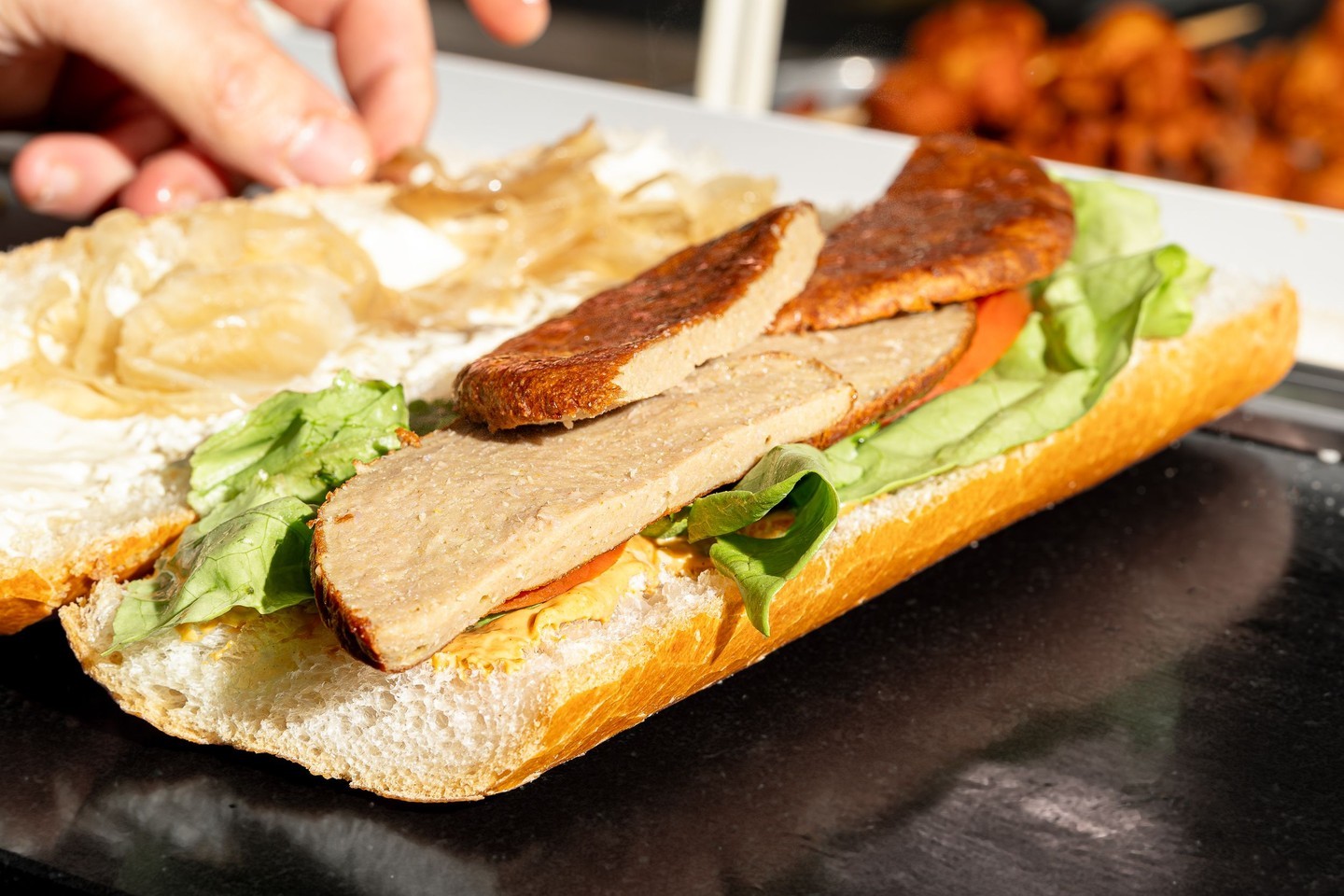 Un sandwich avec de la laitue, des tomates et des tranches de viande au Fritiko, un restaurant halal à Molenbeek-Saint-Jean, Belgique.