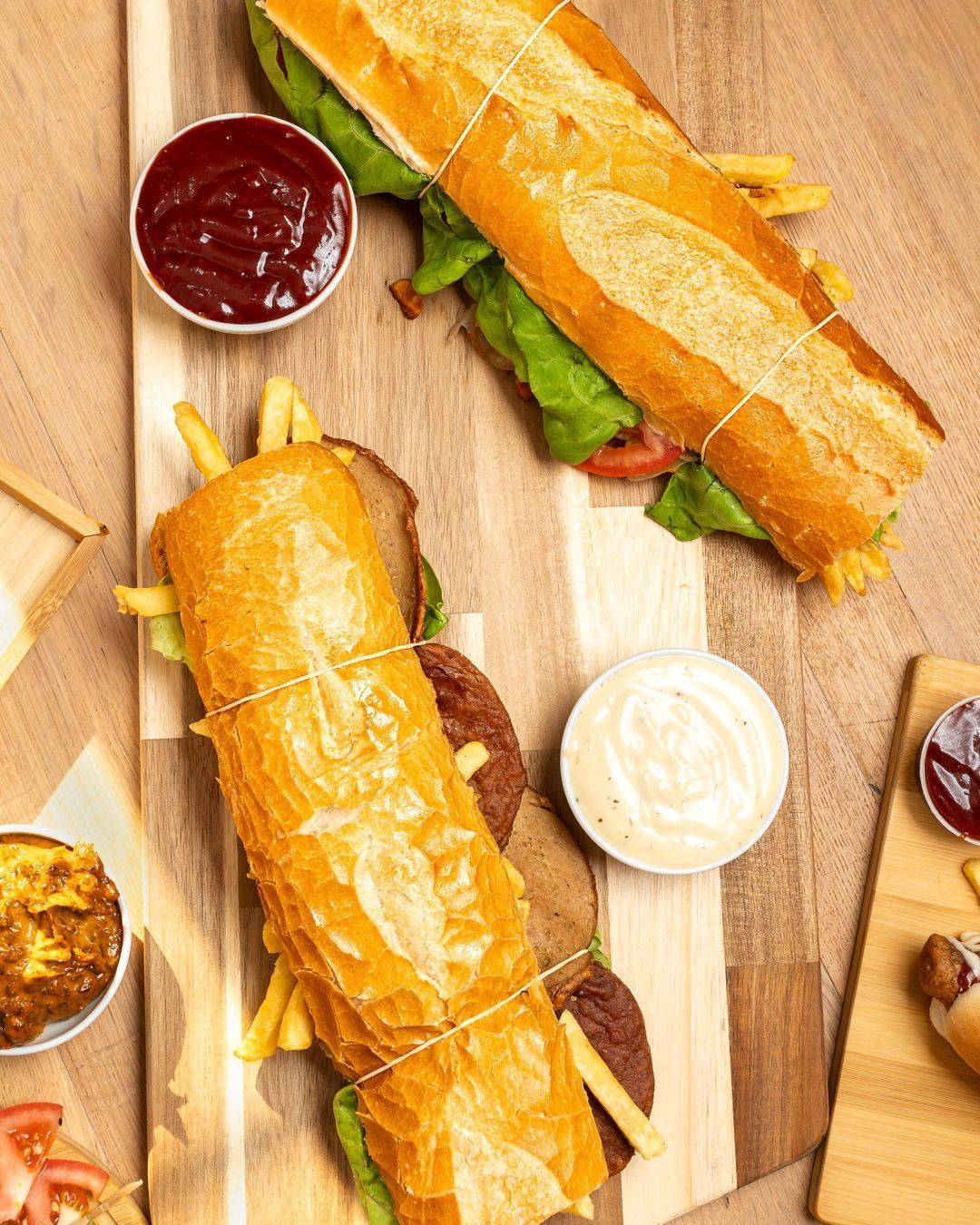 Un grand sandwich garni de laitue, tomate et frites, servi avec du ketchup et de la mayonnaise au Fritiko, un restaurant halal à Molenbeek-Saint-Jean, Belgique.