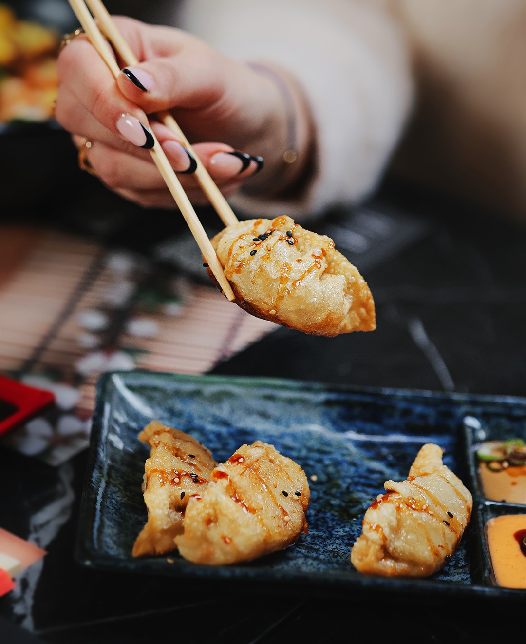 A plate of crispy dumplings with a drizzle of sauce at Sensei Sushi, a halal restaurant in Schaerbeek, Belgium.