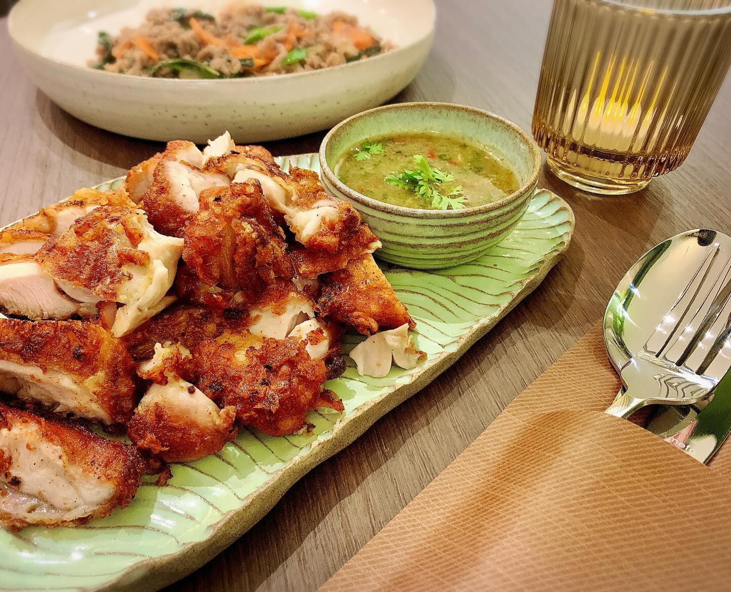 A plate of crispy fried chicken served with a green dipping sauce at Aari Thai, a halal restaurant in Antwerpen, Belgium.