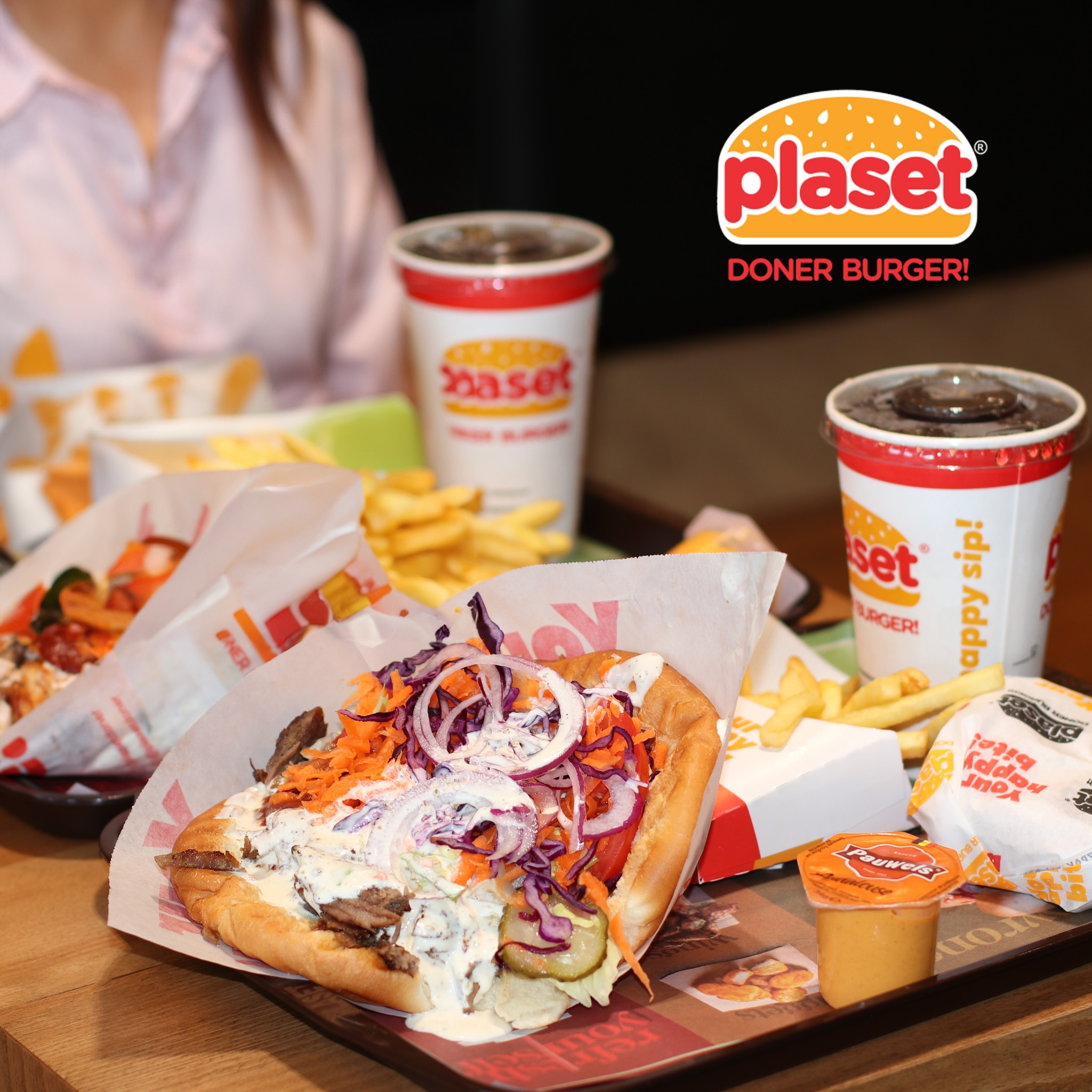 Un kebab döner avec des légumes et de la sauce au Plaset Doner Burger, un restaurant halal à Ixelles, Belgique.