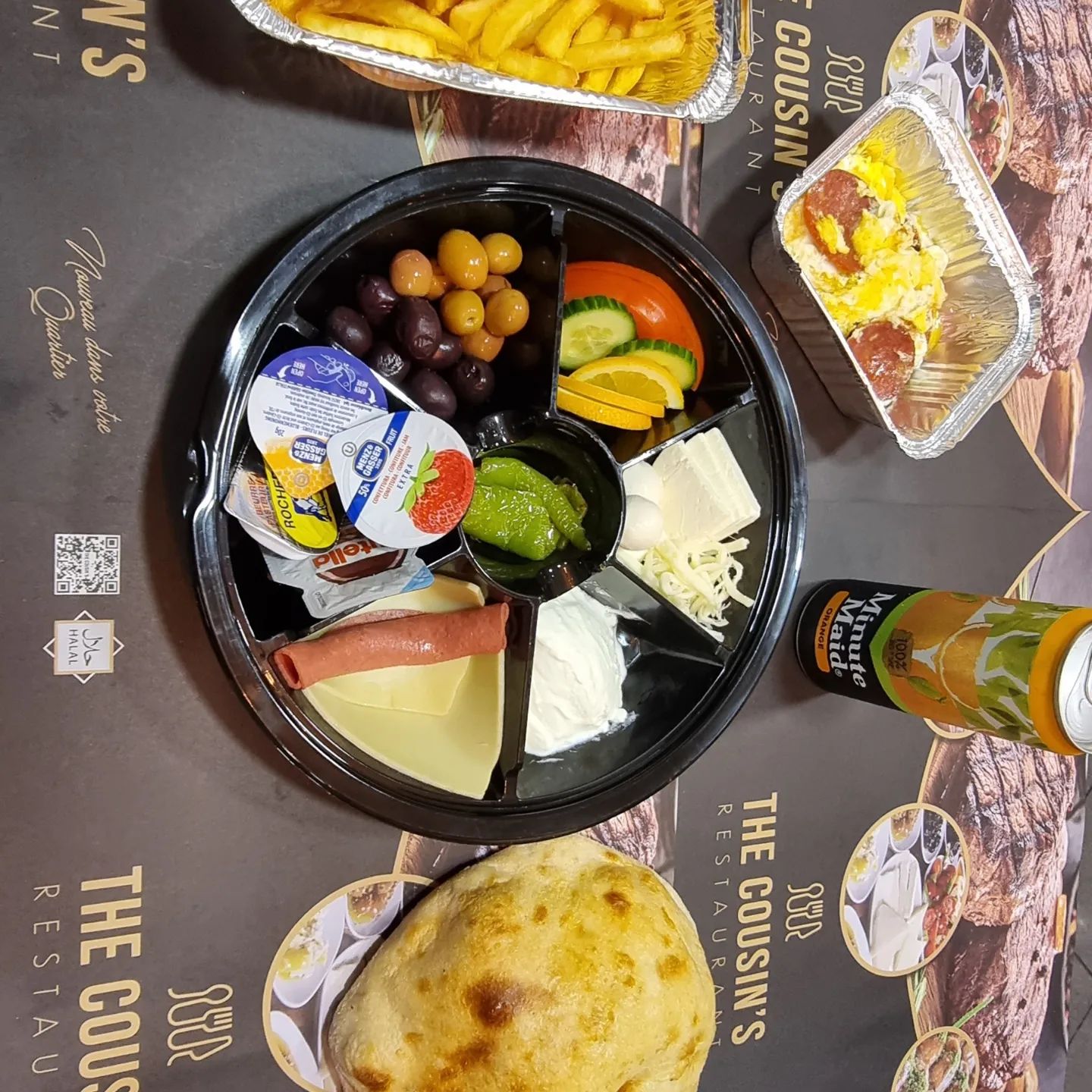 Un plateau de fromages, olives et légumes variés au restaurant halal The Cousins à Bruxelles, Belgique.