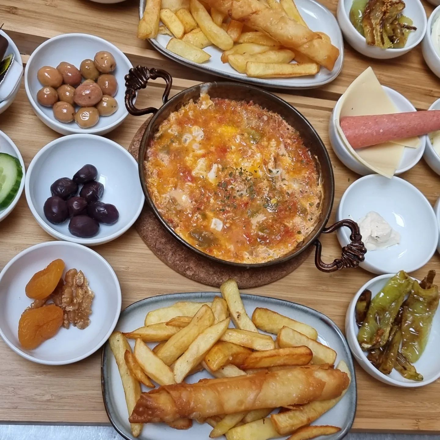 Une assiette de fromage et légumes cuits au four avec des frites, des olives, des cornichons et des fruits secs au restaurant halal The Cousins à Bruxelles, Belgique.