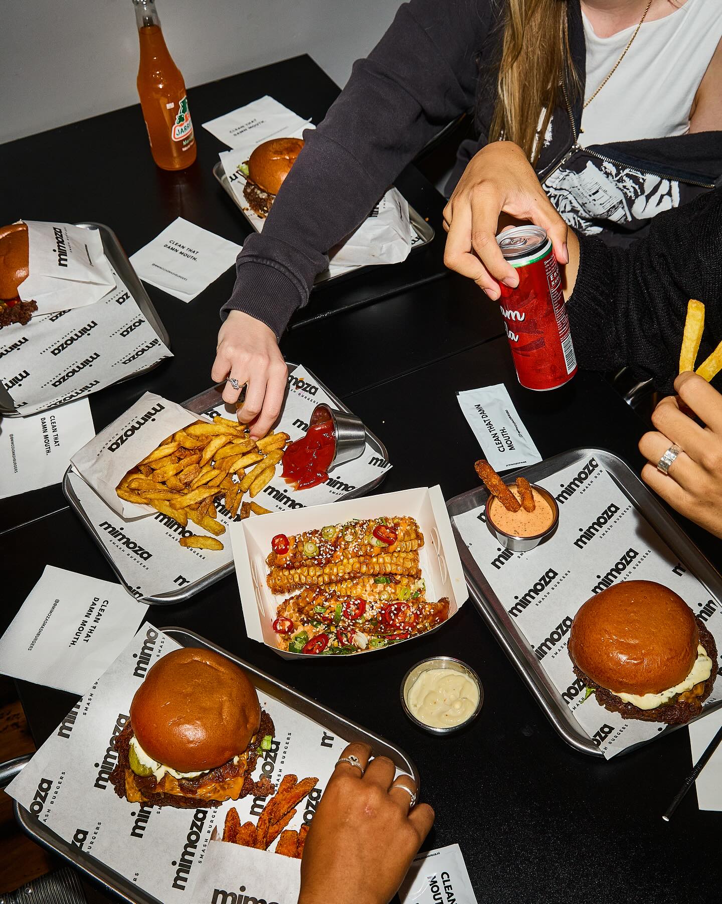 A variety of dishes including burgers, fries, and corn at Mimoza Smashburgers, a halal restaurant in Rotterdam, Netherlands.