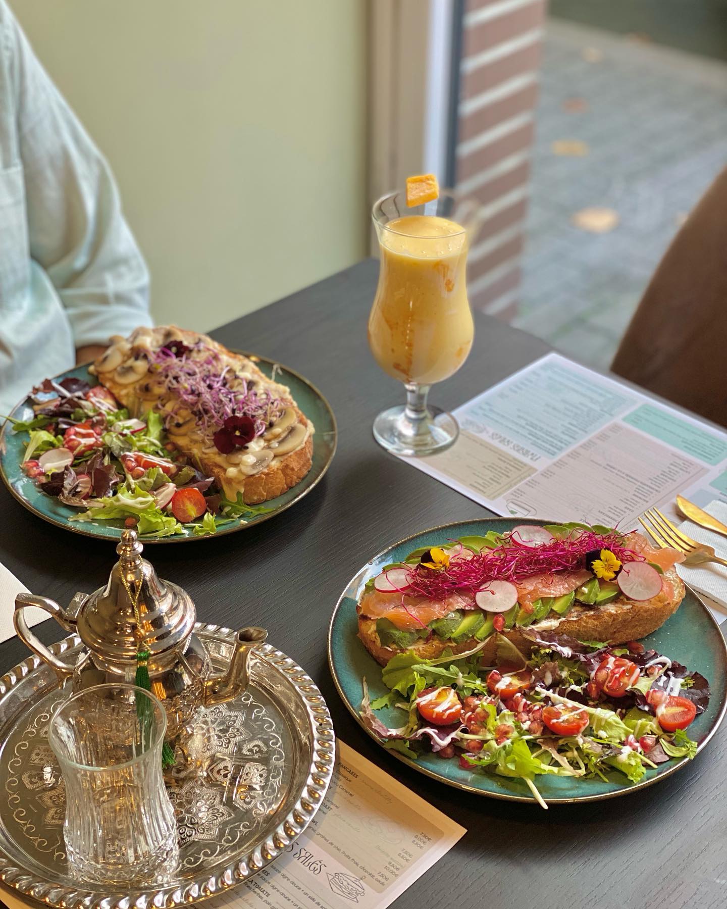 A colorful plate of open-faced sandwiches with salad and a smoothie at Riad, a halal restaurant in Molenbeek-Saint-Jean, Belgium.