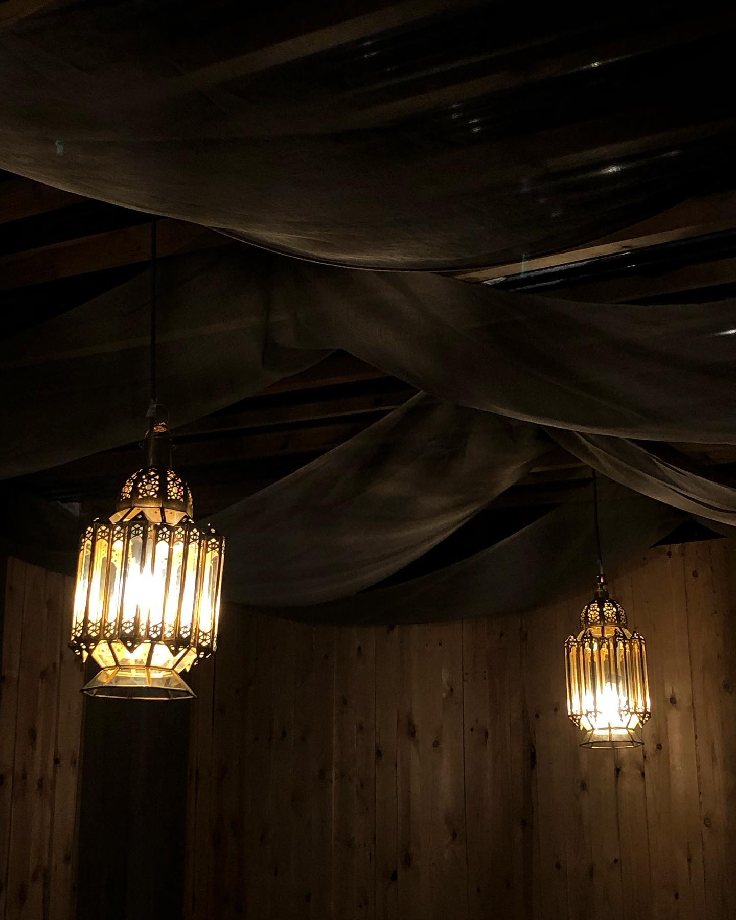 The interior of halal restaurant Riad in Molenbeek-Saint-Jean, Belgium, showing ornate lanterns hanging from the ceiling and wooden walls.