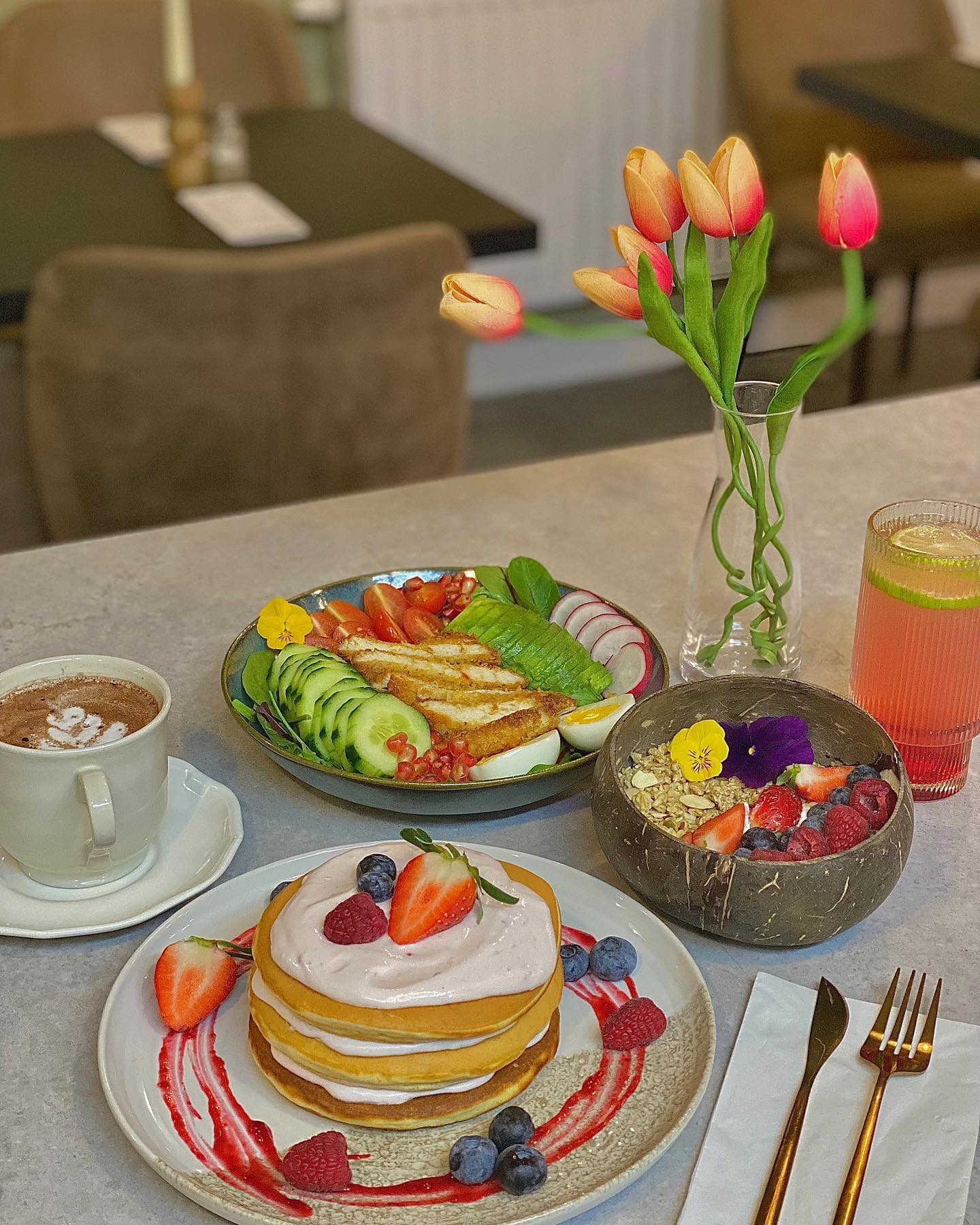 A stack of pancakes with berry toppings and a side of fruit, served at Riad, a halal restaurant in Molenbeek-Saint-Jean, Belgium.