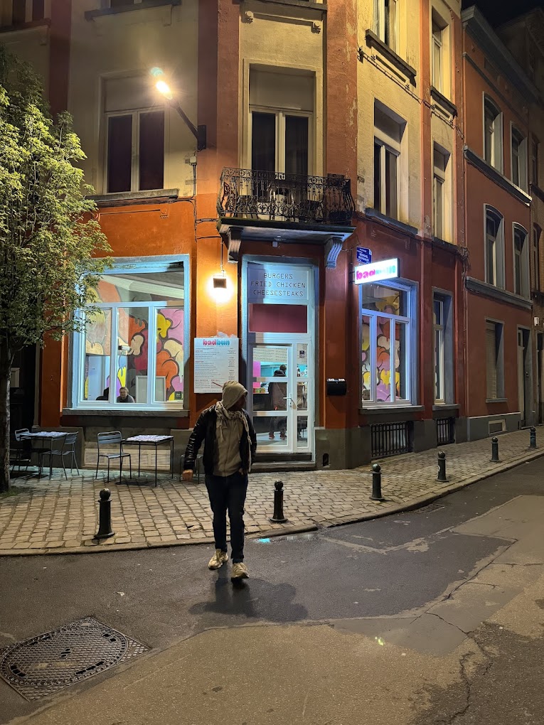 The exterior of halal restaurant Bad Bun in Ixelles, Belgium, showing a colorful facade with large windows and outdoor seating.