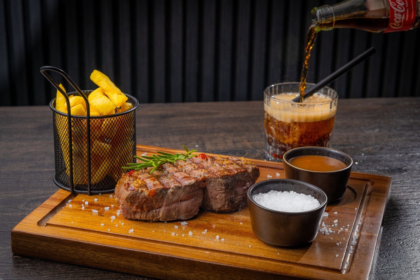 A grilled steak with rosemary, served with fries, salt, and two sauces at La Ruche, a halal restaurant in Eindhoven, Netherlands.