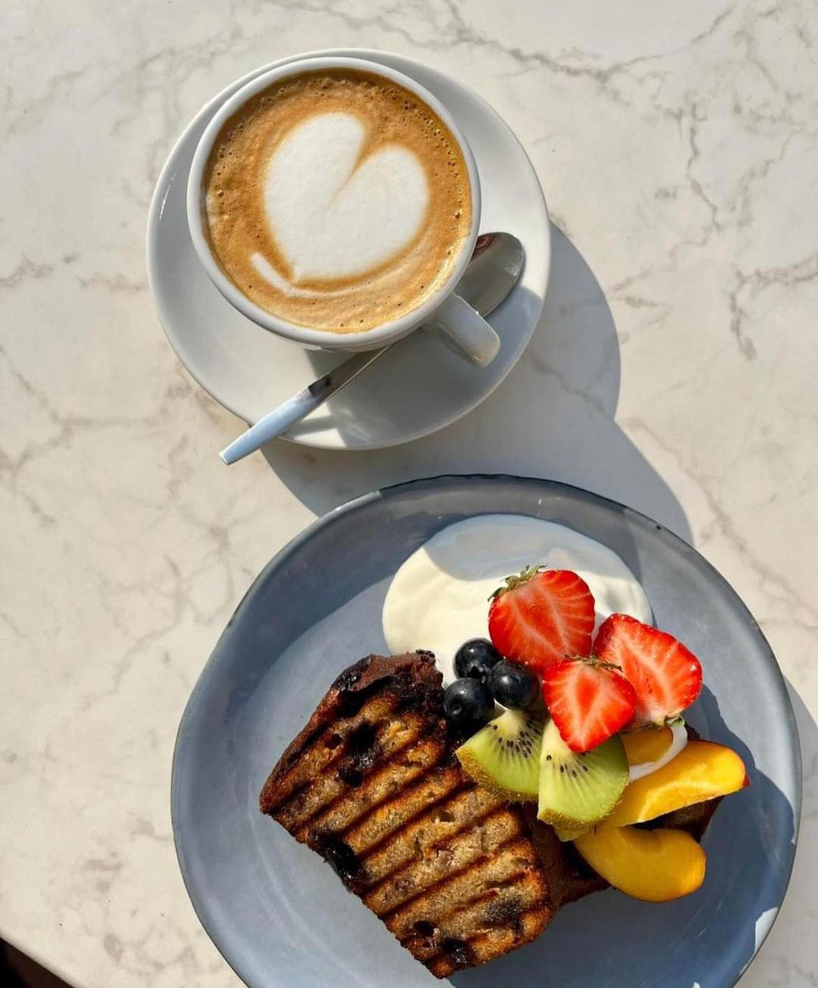 A slice of grilled banana bread topped with fresh fruits and a dollop of yogurt at Koffie Met Tony, a halal restaurant in Ede, Netherlands.
