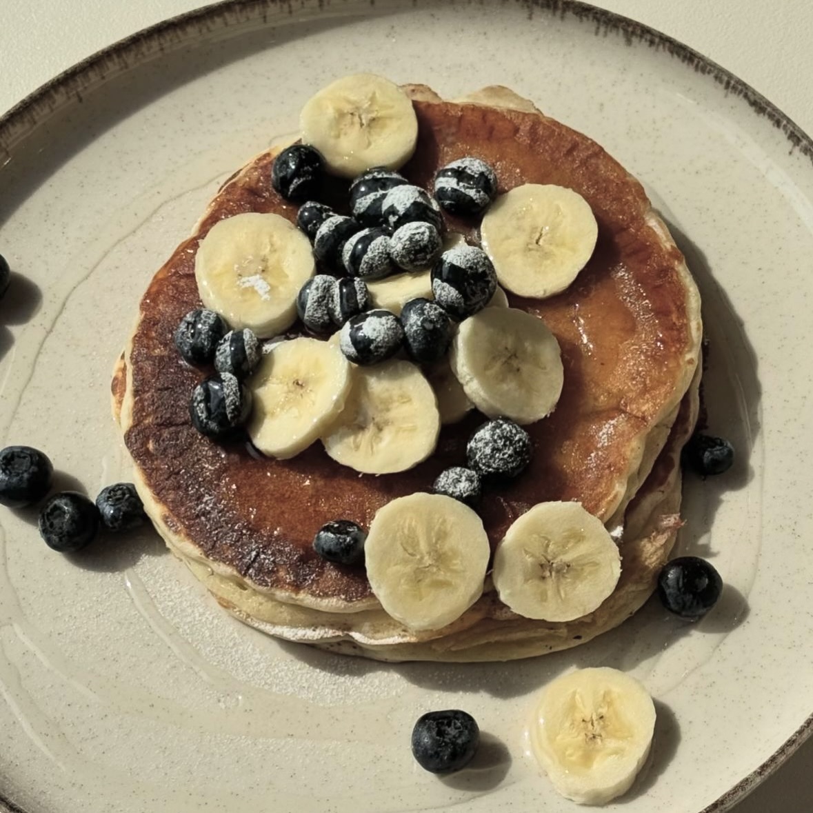 A stack of pancakes topped with banana slices and blueberries at The Bread Bar, a halal restaurant in Gent, Belgium.