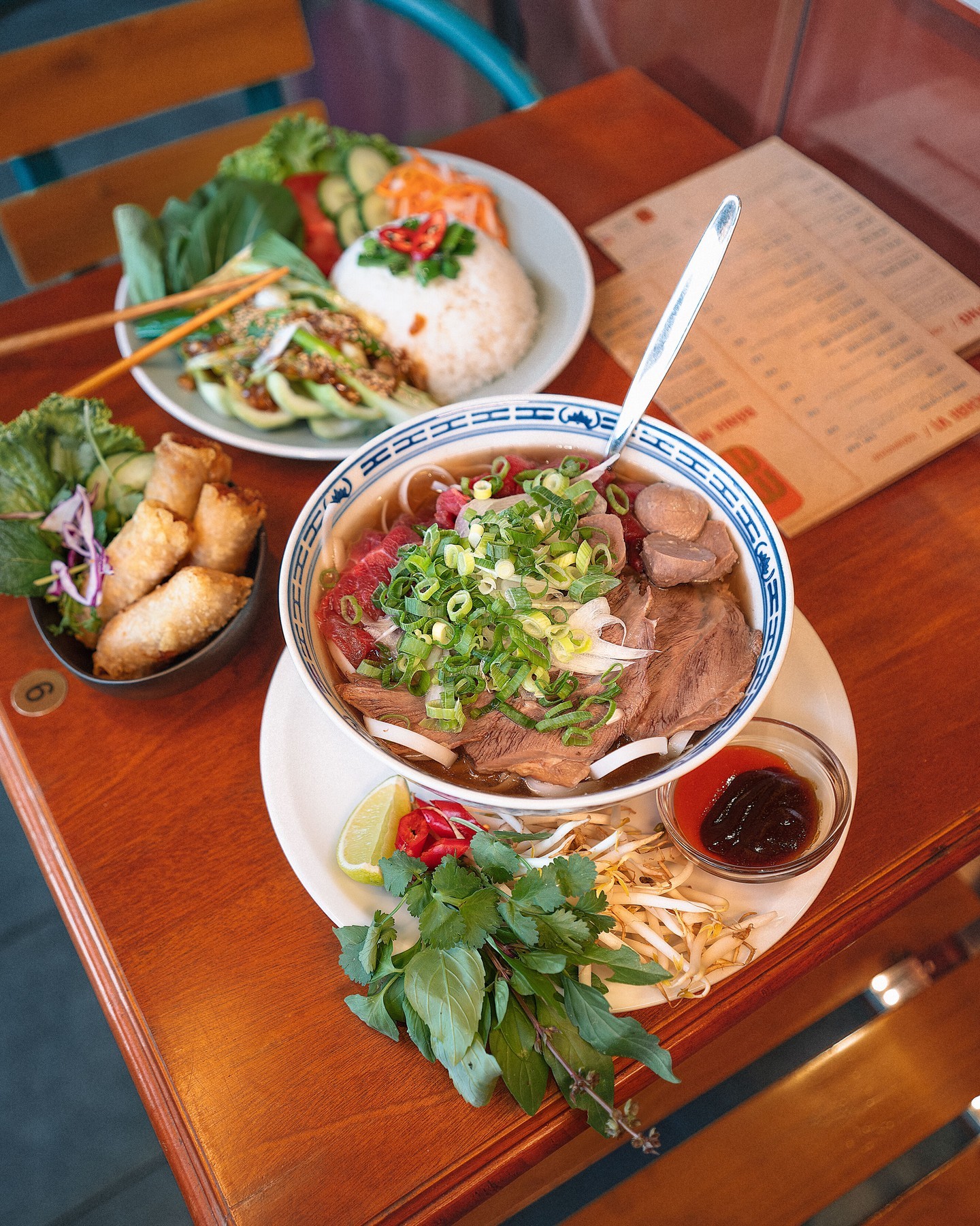 A bowl of pho with beef, topped with green onions, bean sprouts, lime, and herbs at MeMe, a halal restaurant in Rotterdam, Netherlands.