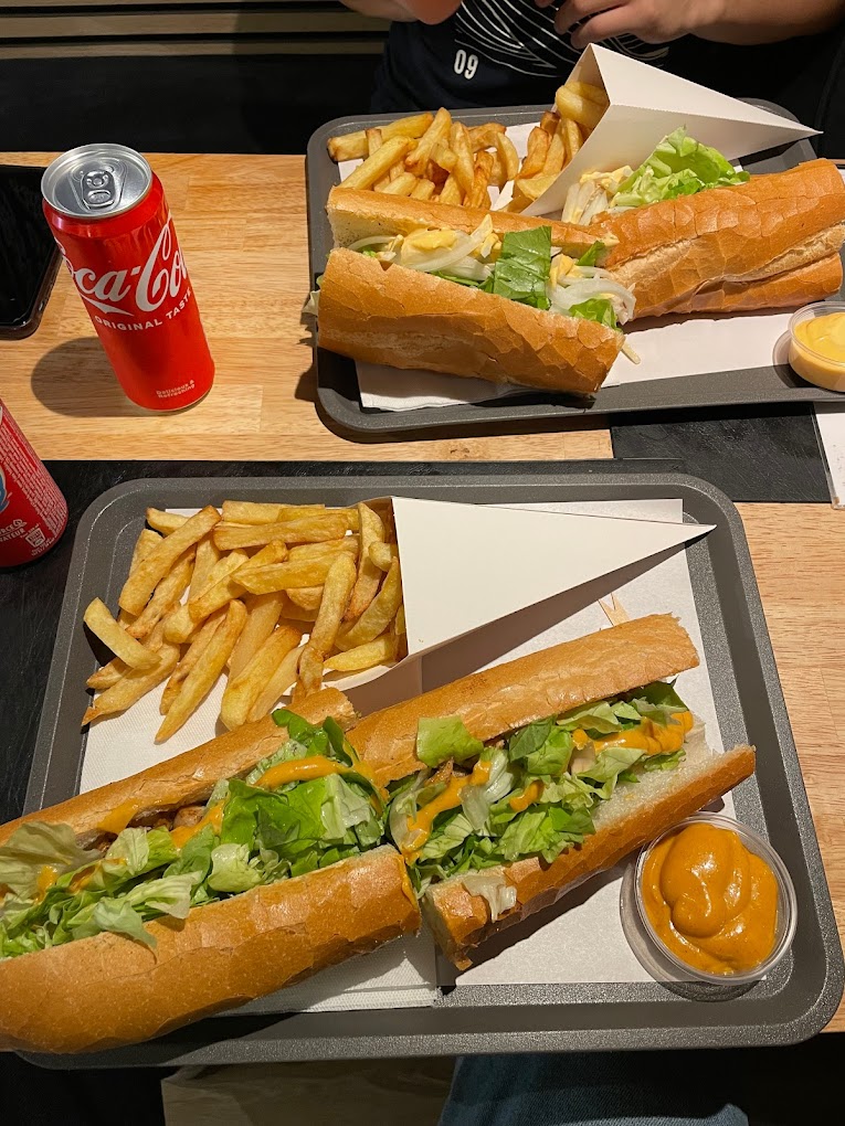 A sandwich with lettuce and sauce, accompanied by fries and a can of Coca-Cola at Joe La Frite, a halal restaurant in Bruxelles, Belgium.