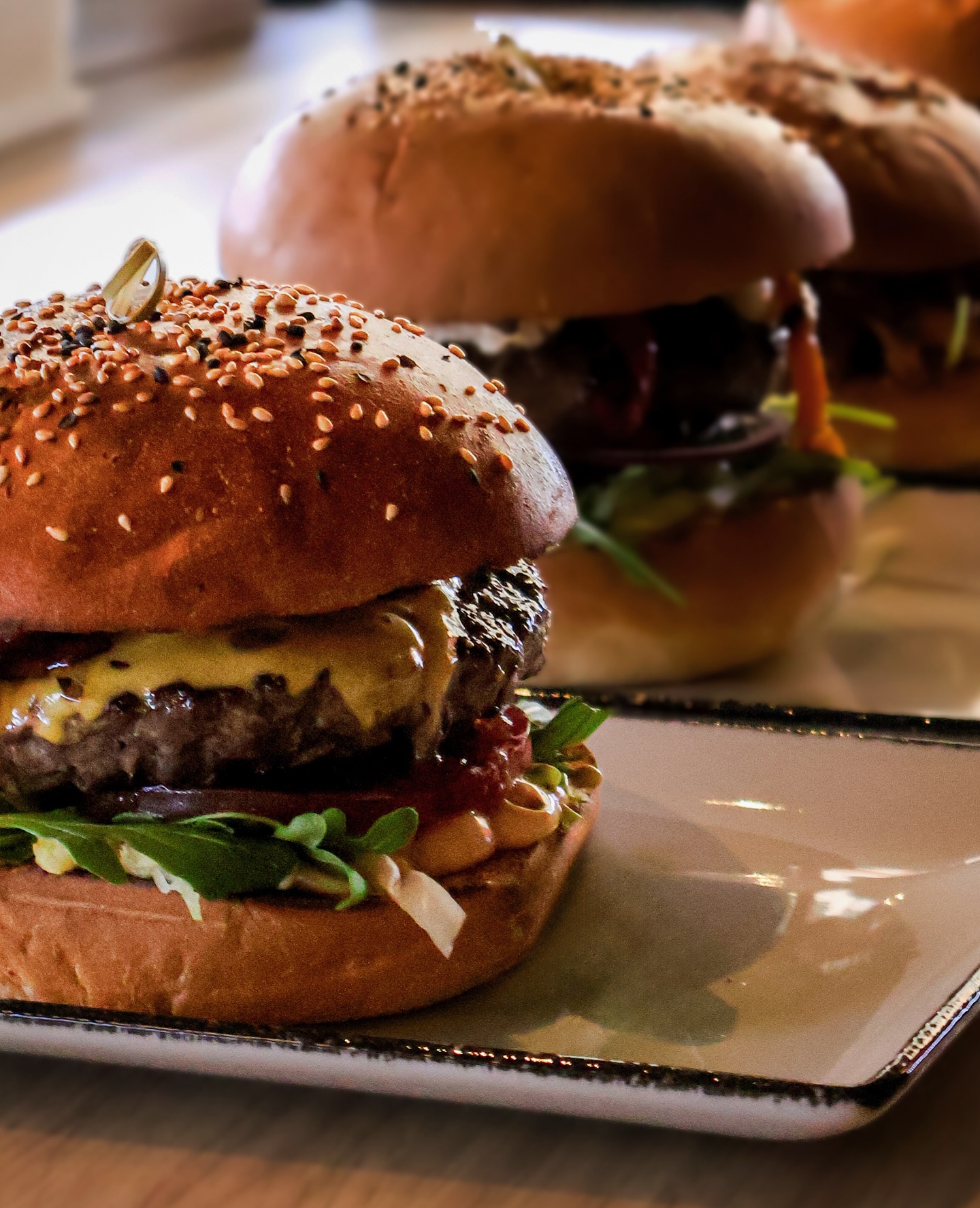 A close-up of a cheeseburger with sesame seed bun, lettuce, tomato, and sauce at Just Burgers, a halal restaurant in Gorinchem, Netherlands.