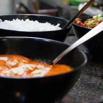 Een kom kipcurry met rijst bij Curryosity, een halal restaurant in Antwerpen, België.