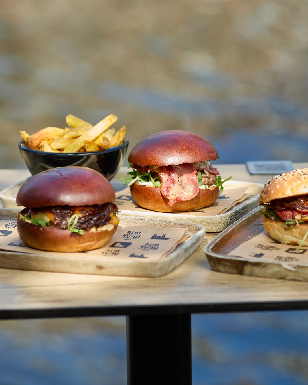 A selection of three gourmet burgers and a bowl of fries at Burger Bar, a halal restaurant in Amsterdam, Netherlands.