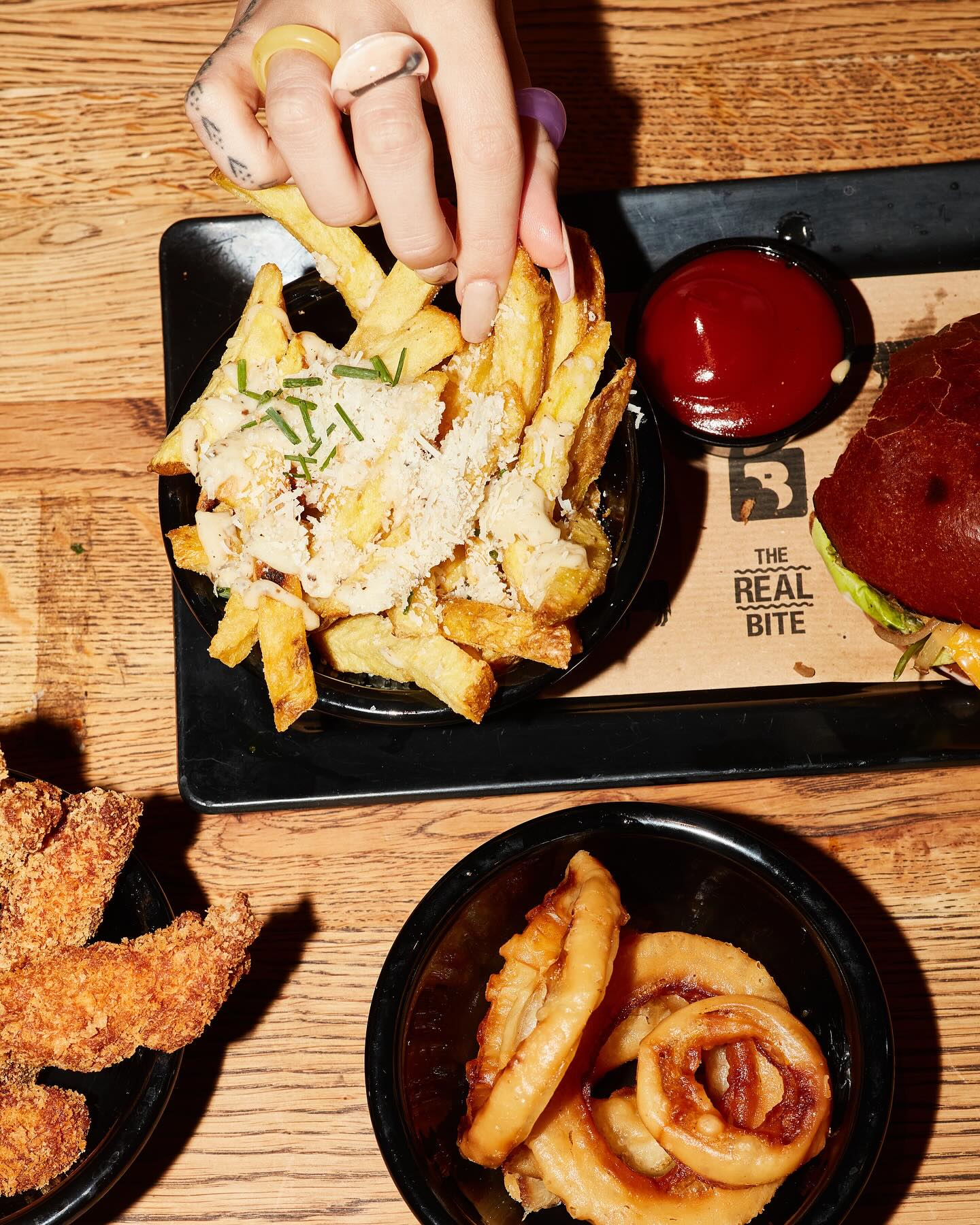 Een bord frietjes belegd met kaas en kruiden bij Burger Bar, een halal restaurant in Amsterdam, Nederland.