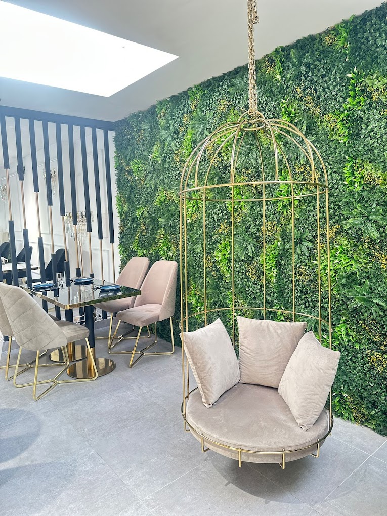 The interior of halal restaurant Liva Restaurant & Café in Antwerpen, Belgium, showing a hanging chair surrounded by greenery and modern furniture.