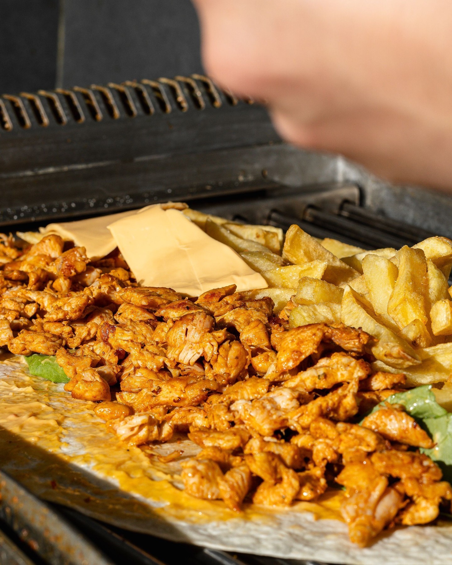 Une assiette de poulet grillé avec du fromage et des frites au Fritiko, un restaurant halal à Ganshoren, en Belgique.