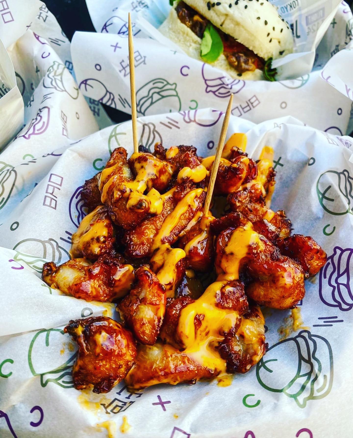 Een bord met kippenvleugels bedekt met kaassaus bij GOMU, een halal restaurant in Brussel, België.