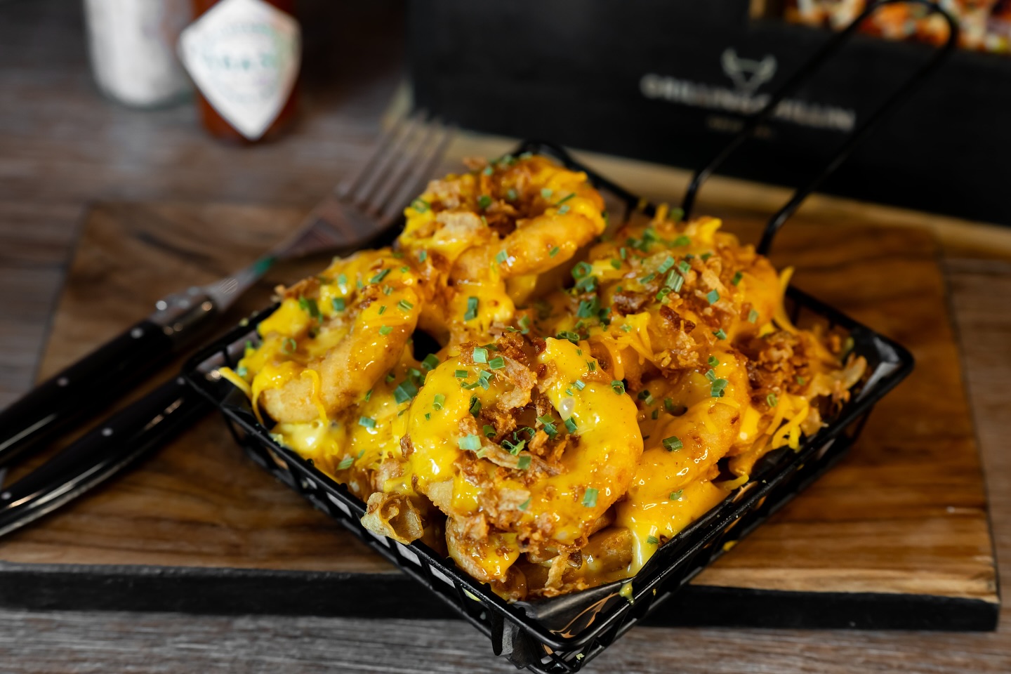A plate of cheesy loaded fries topped with crispy onions and herbs at King Ribs, a halal restaurant in Gent, Belgium.